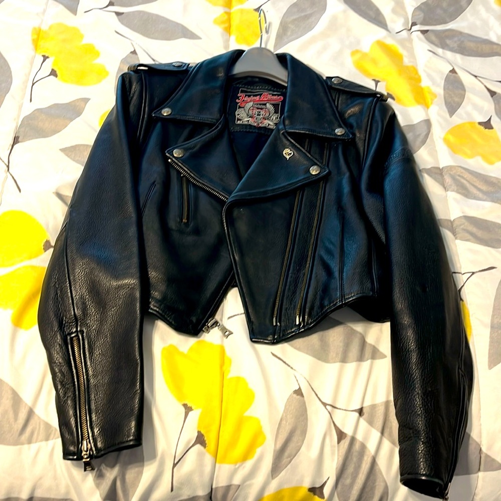 Cropped leather jacket with zipper sleeves.